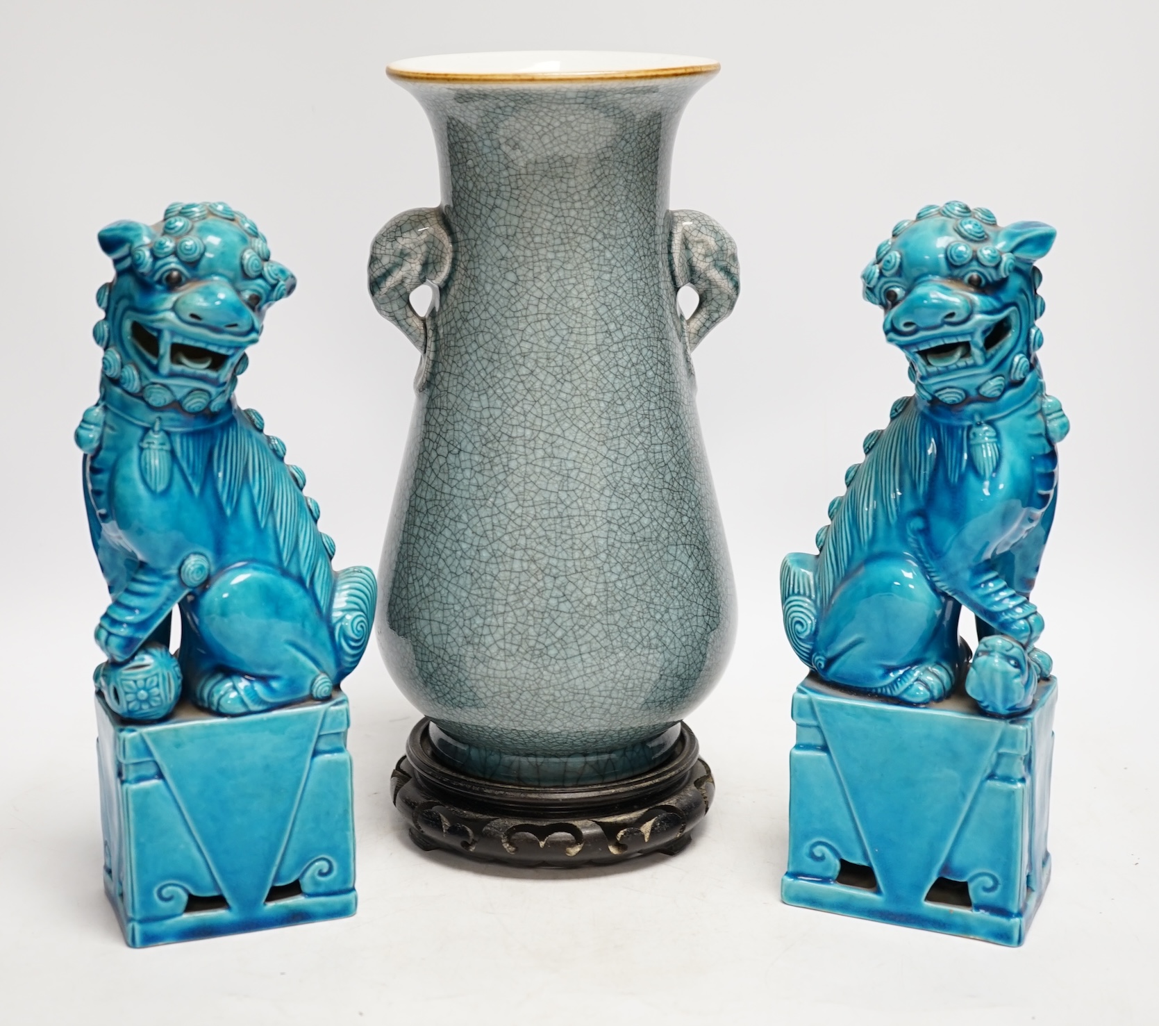 A pair of early 20th century Chinese turquoise glazed dogs of fo and a crackle glazed vase on stand, tallest 29cm. Condition - good, vase has drill hole to base